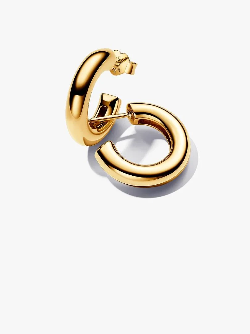 Pair of open hoop earrings in gold, side view with high angle shot on a white background.