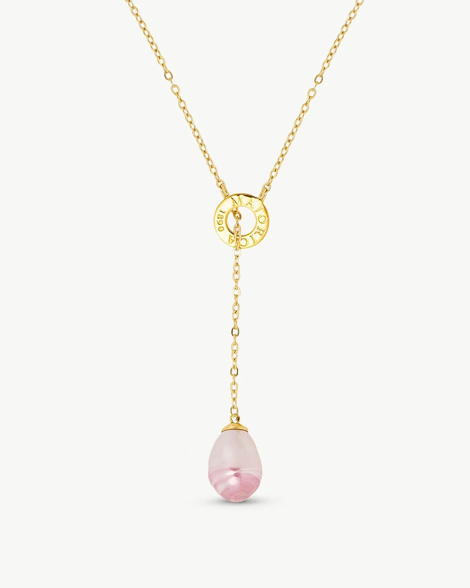 Collier avec perle baroque rose vue de face sur fond blanc, détail du maillon circulaire gravé.