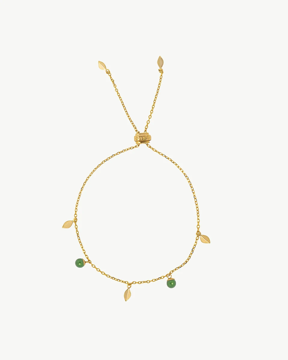 Gold chain bracelet with leaf charms and green pearls, front view on white background.