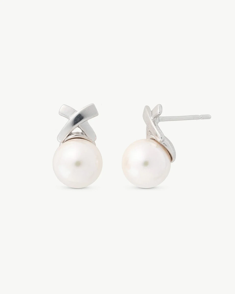 Pair of white pearl stud earrings with silver X-shaped setting, front view on a white background.
