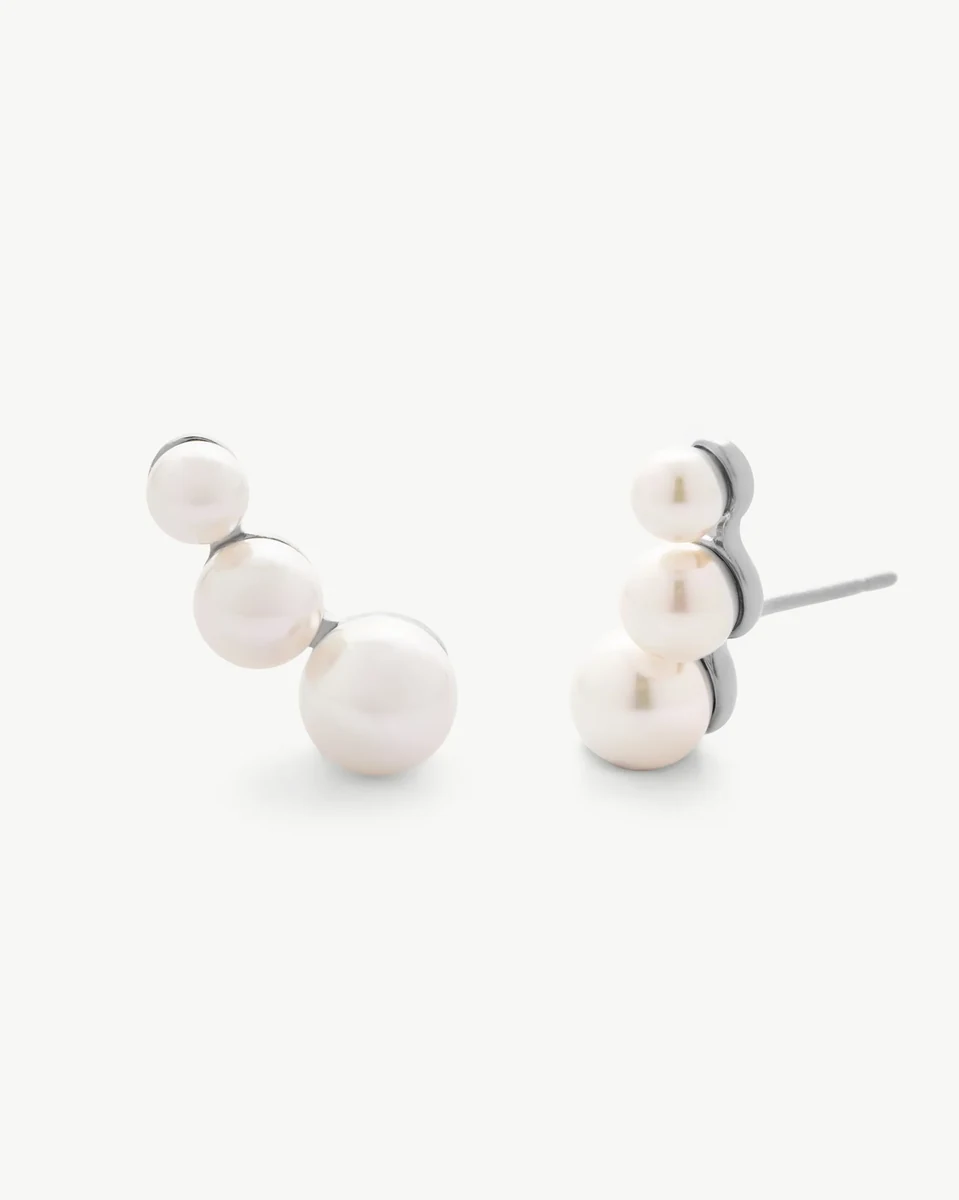 Vista frontal de los pendientes con tres perlas blancas graduadas, sobre fondo blanco puro.