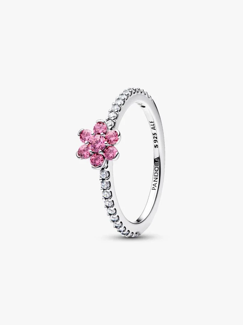 Silver ring with pink floral motif shown from a side angle on a white background.