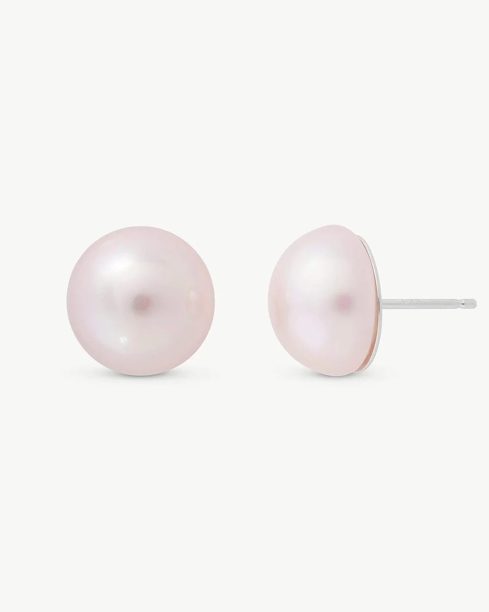 Vue de face et de profil des boucles d'oreilles demi-perle rose sur fond blanc.