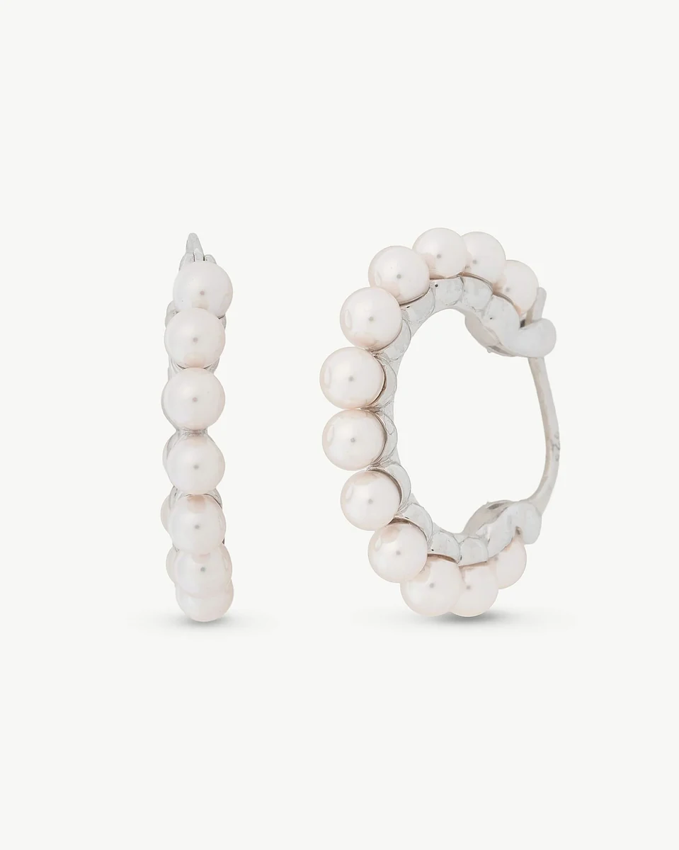 Front view of pearl hoop earrings on a white background, slightly angled shot.