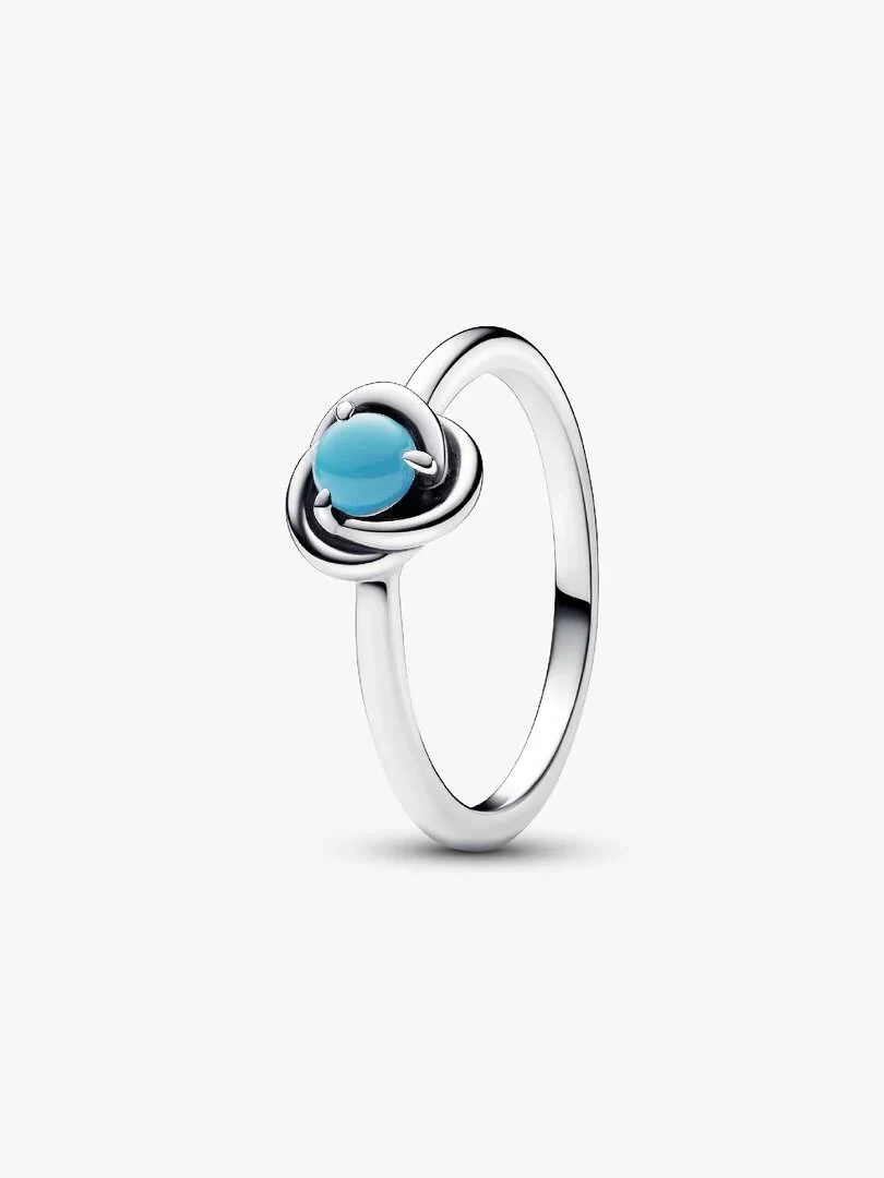 Zilveren ring met turquoise steen in zijaanzicht, zuiver witte achtergrond.