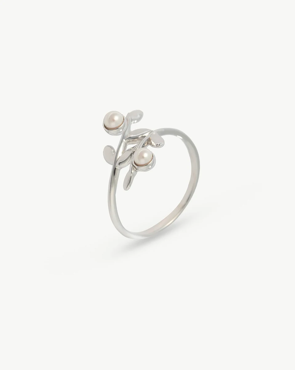 Bague en argent au design organique de feuilles et perles, vue de profil sur fond blanc.