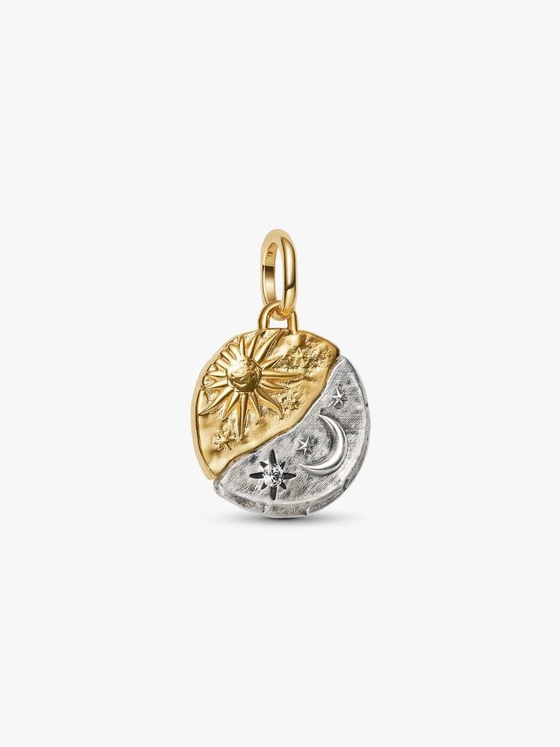 Rond medaillon charm met zon- en maantjesmotieven, vooraanzicht op een witte achtergrond.