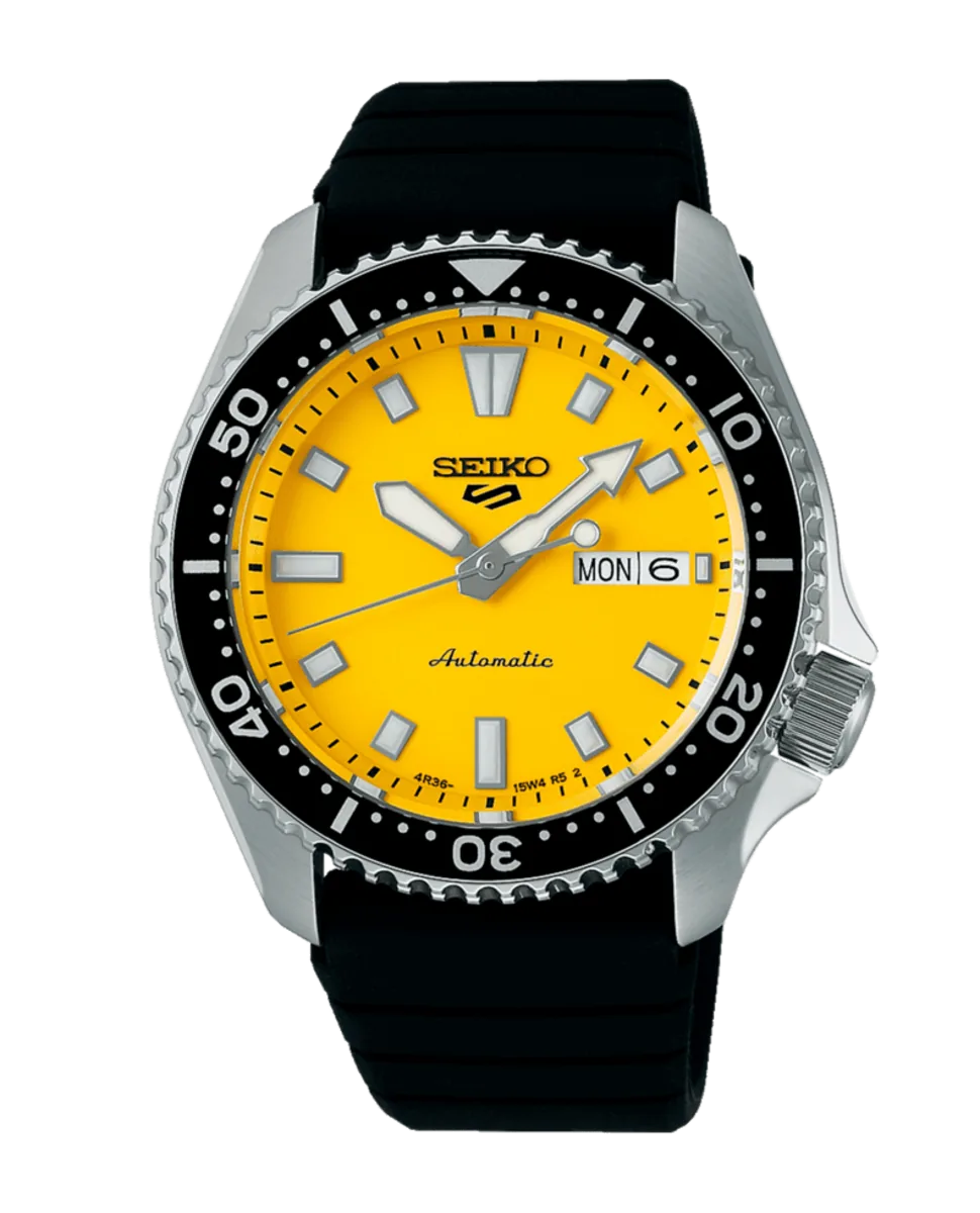 Vista frontal completa del reloj con esfera amarilla y correa negra sobre fondo blanco.