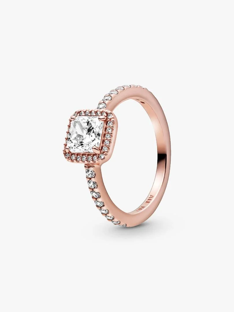 Anillo de oro rosa con circonita cuadrada, vista lateral en ángulo sobre fondo blanco.