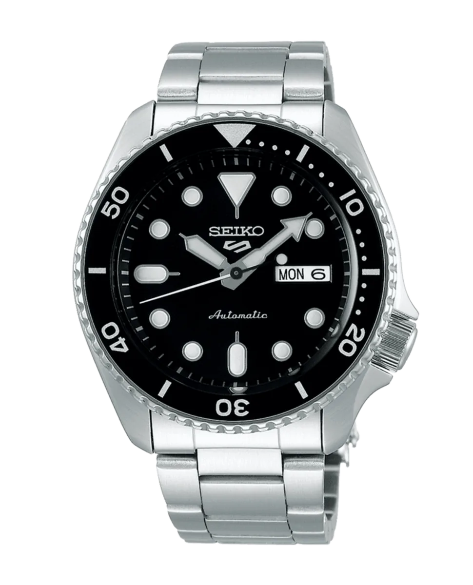 Vista frontal completa del reloj con esfera negra y brazalete de acero sobre fondo blanco.