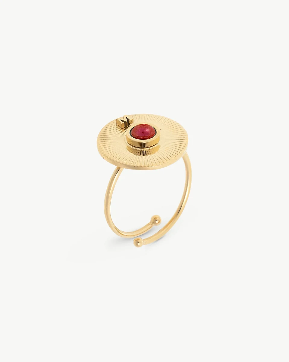 Anillo ajustable de acero dorado con perla roja, vista lateral en ángulo sobre fondo blanco.
