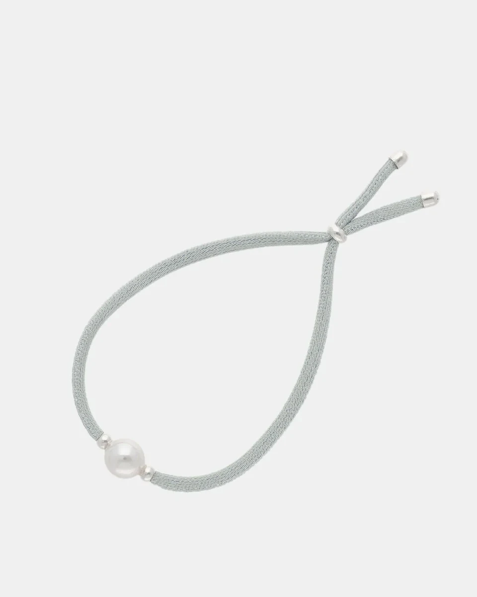 Elastic bracelet viewed from a top angle, white background, detail of the pearl and adjustable closure.