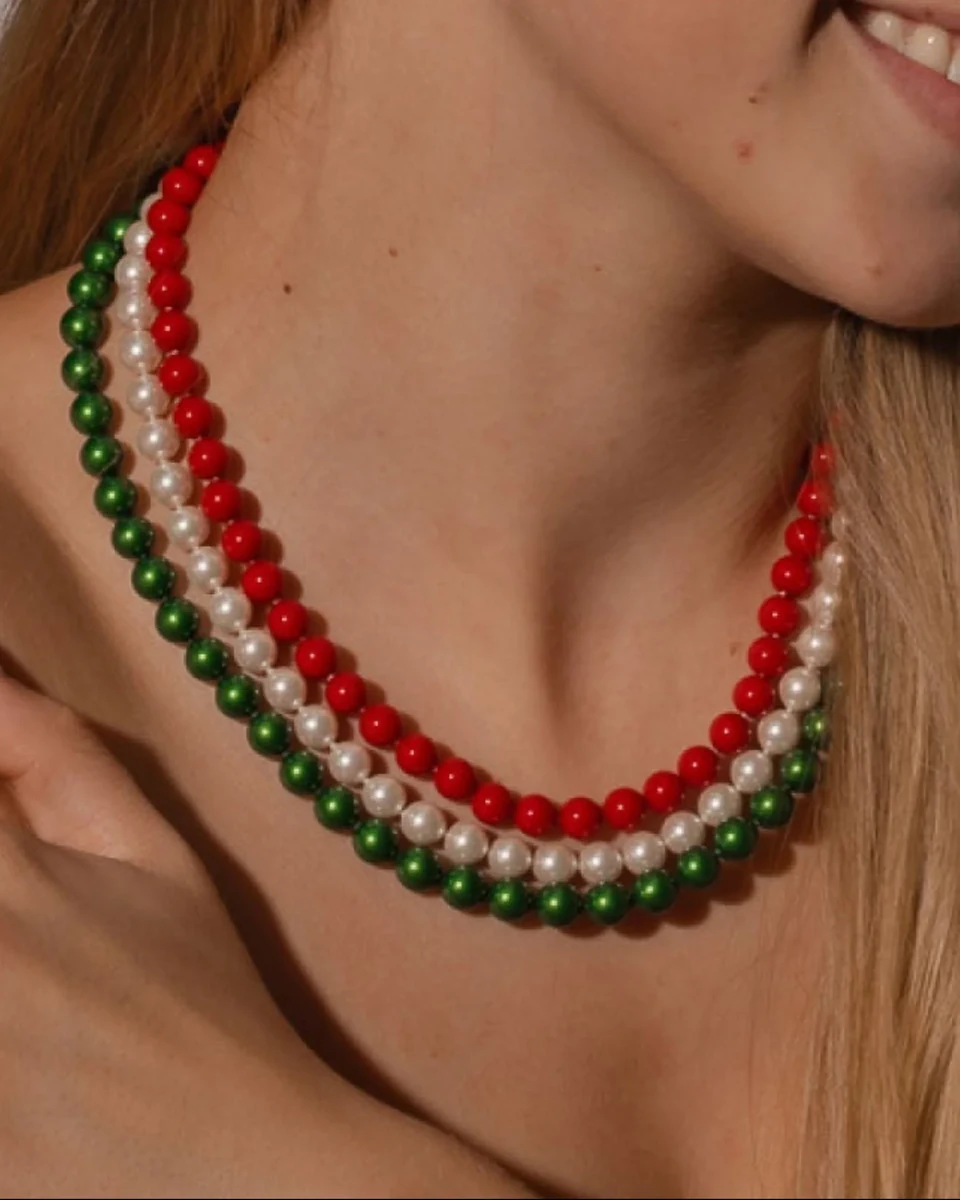 Gros plan du collier à trois rangs sur le cou d'un mannequin, vue de face avec éclairage chaud.