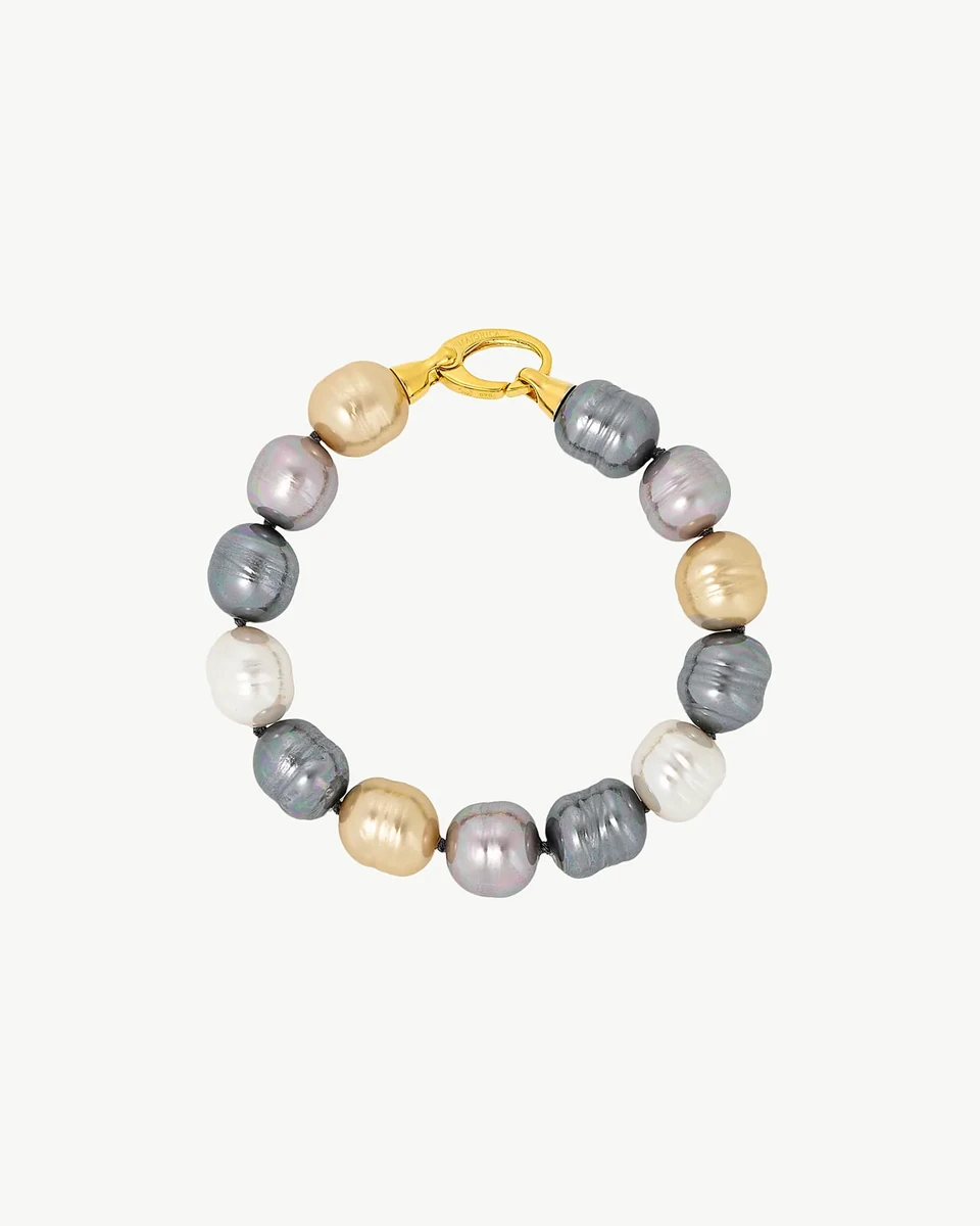Pulsera de perlas barrocas multicolor dispuesta en círculo sobre fondo blanco, vista cenital con cierre visible.