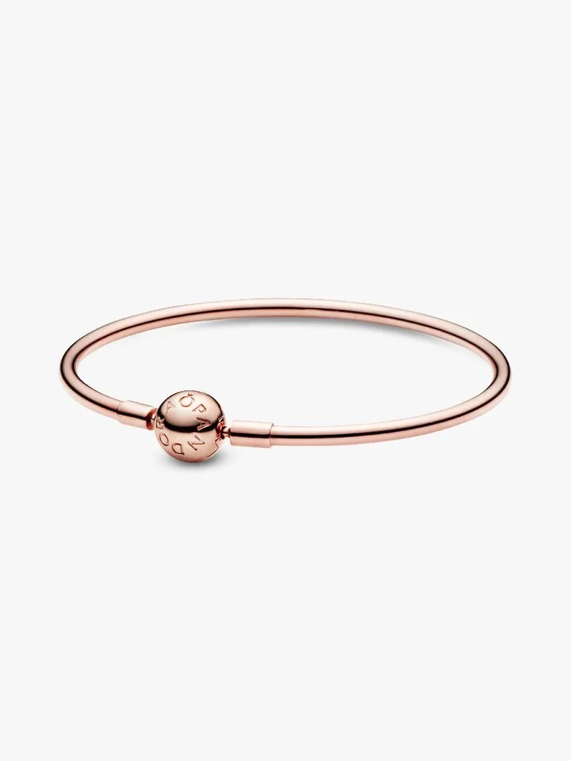 Bracelet en or rose vu de profil sur fond blanc, mettant en avant le fermoir sphérique avec logo.