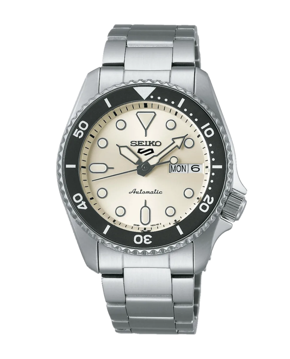 Vista frontal completa del reloj con esfera blanca y brazalete de acero sobre fondo blanco.