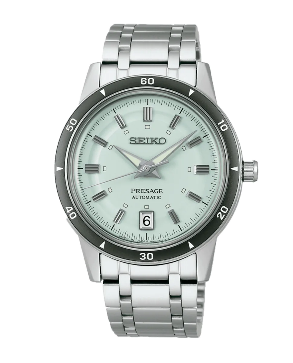 Vista frontal del reloj con esfera verde claro y brazalete de acero sobre fondo blanco.