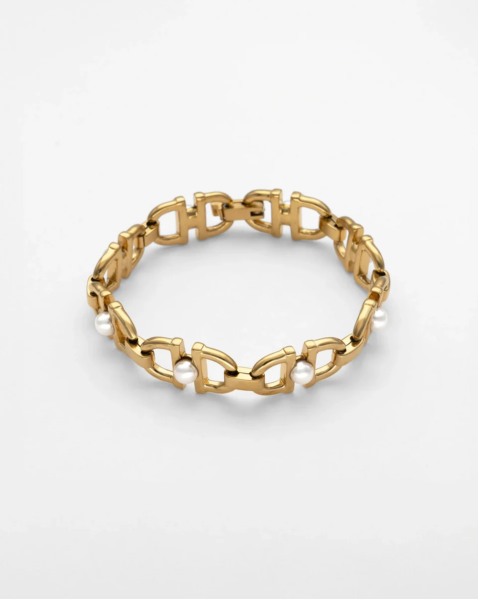 Goldene Gliederarmband mit weißen Perlen, schräge Ansicht auf neutralem weißem Hintergrund.