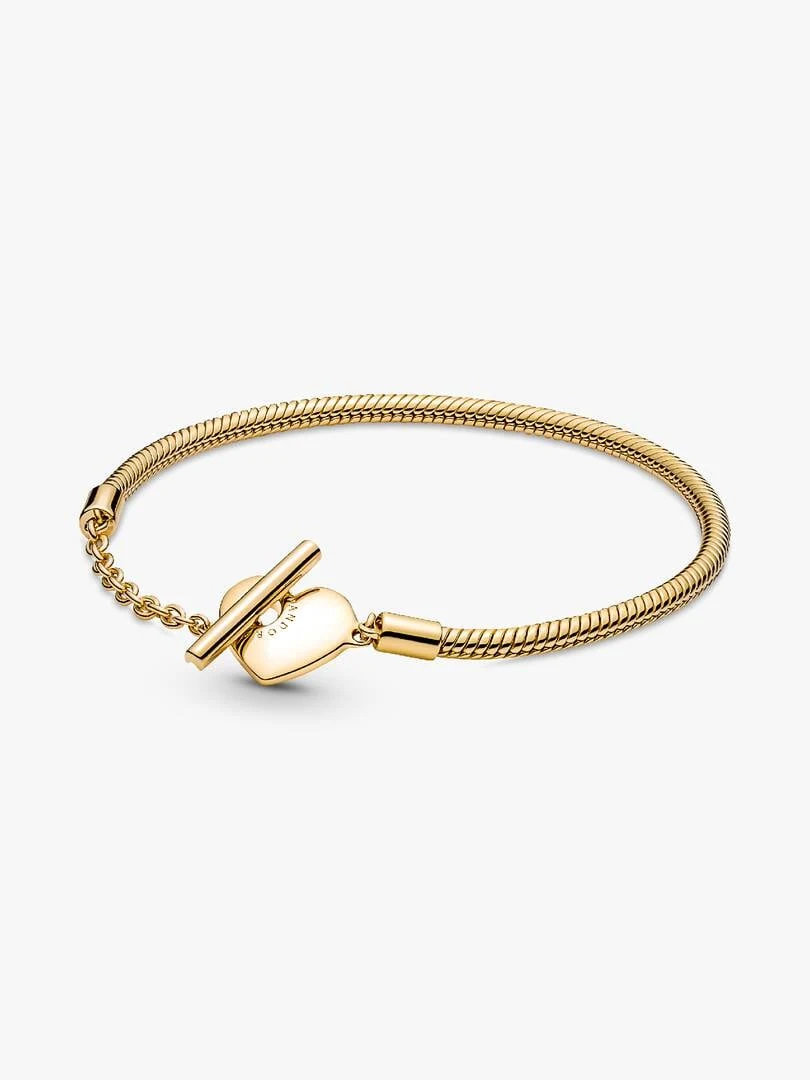 Snake chain bracelet shown at a diagonal angle on a white background, featuring the T-bar clasp and heart charm.