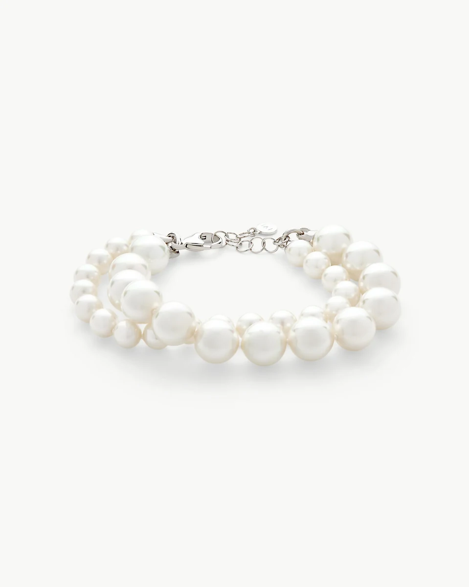 Top view of double-strand white pearl bracelet on a white background, showing the silver clasp.