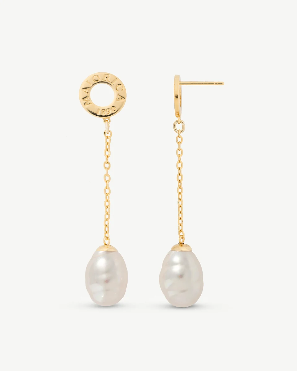 Vista frontal de los pendientes largos con perla barroca y cadena dorada, sobre fondo blanco.