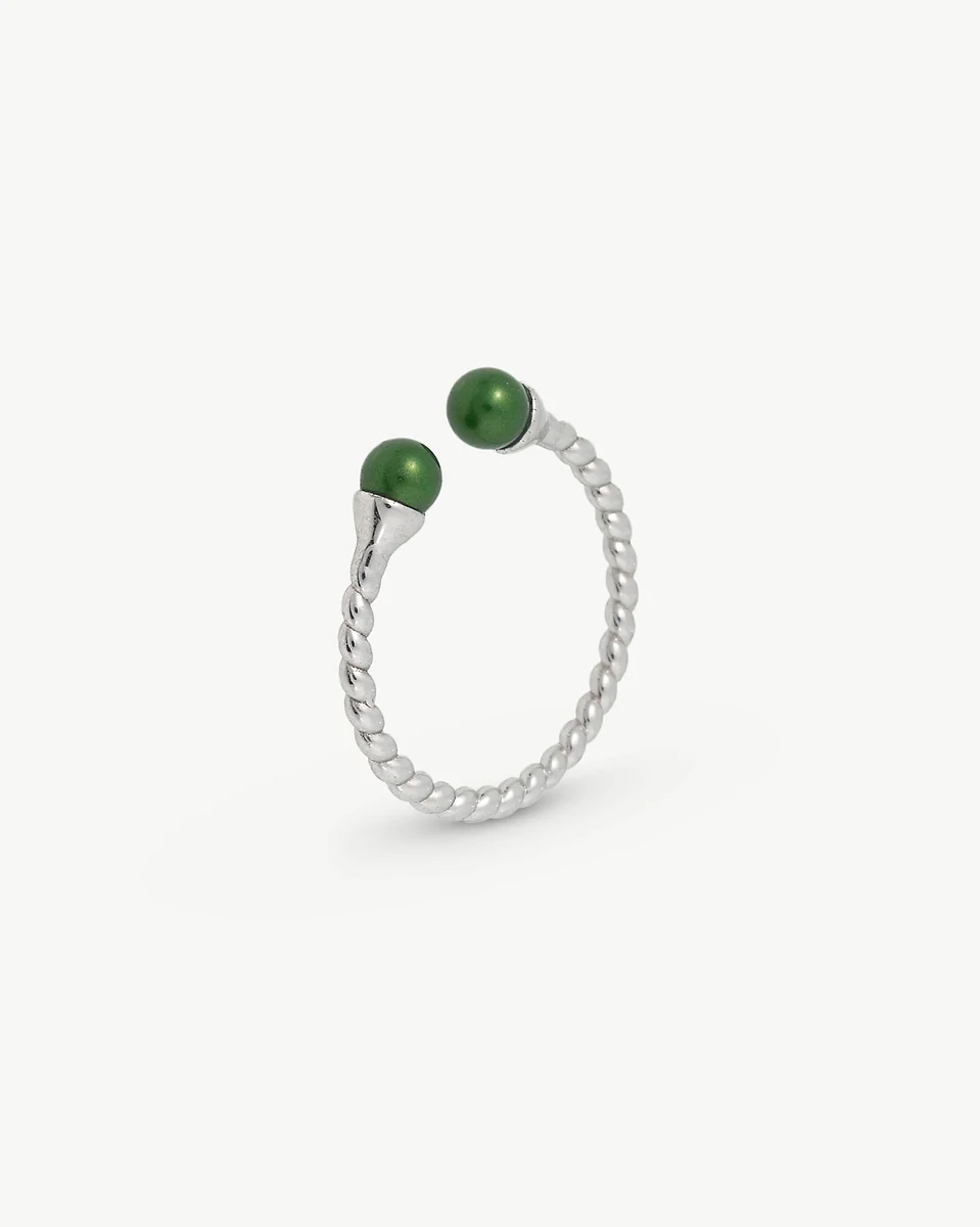Silver twisted band ring with two green pearls, side view on a white background.
