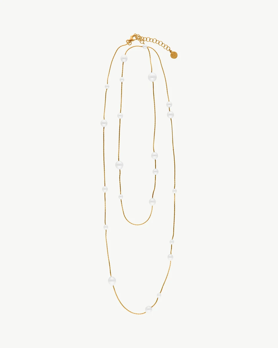 Lange Perlenkette auf weißem Hintergrund, Frontansicht mit Kaskadenfall und feiner Goldkette.