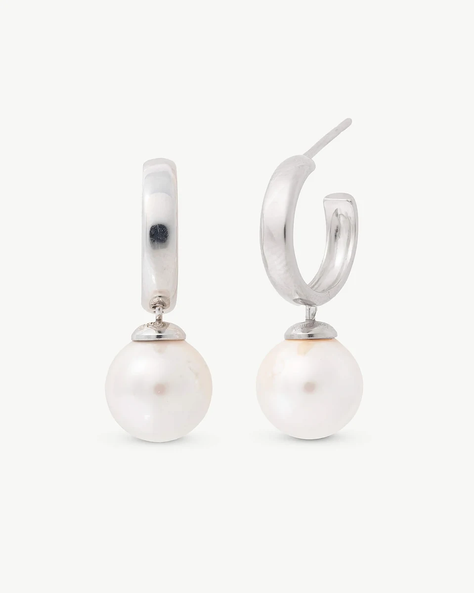 Paar oorringen met witte parel, vooraanzicht op een zuiver witte achtergrond.