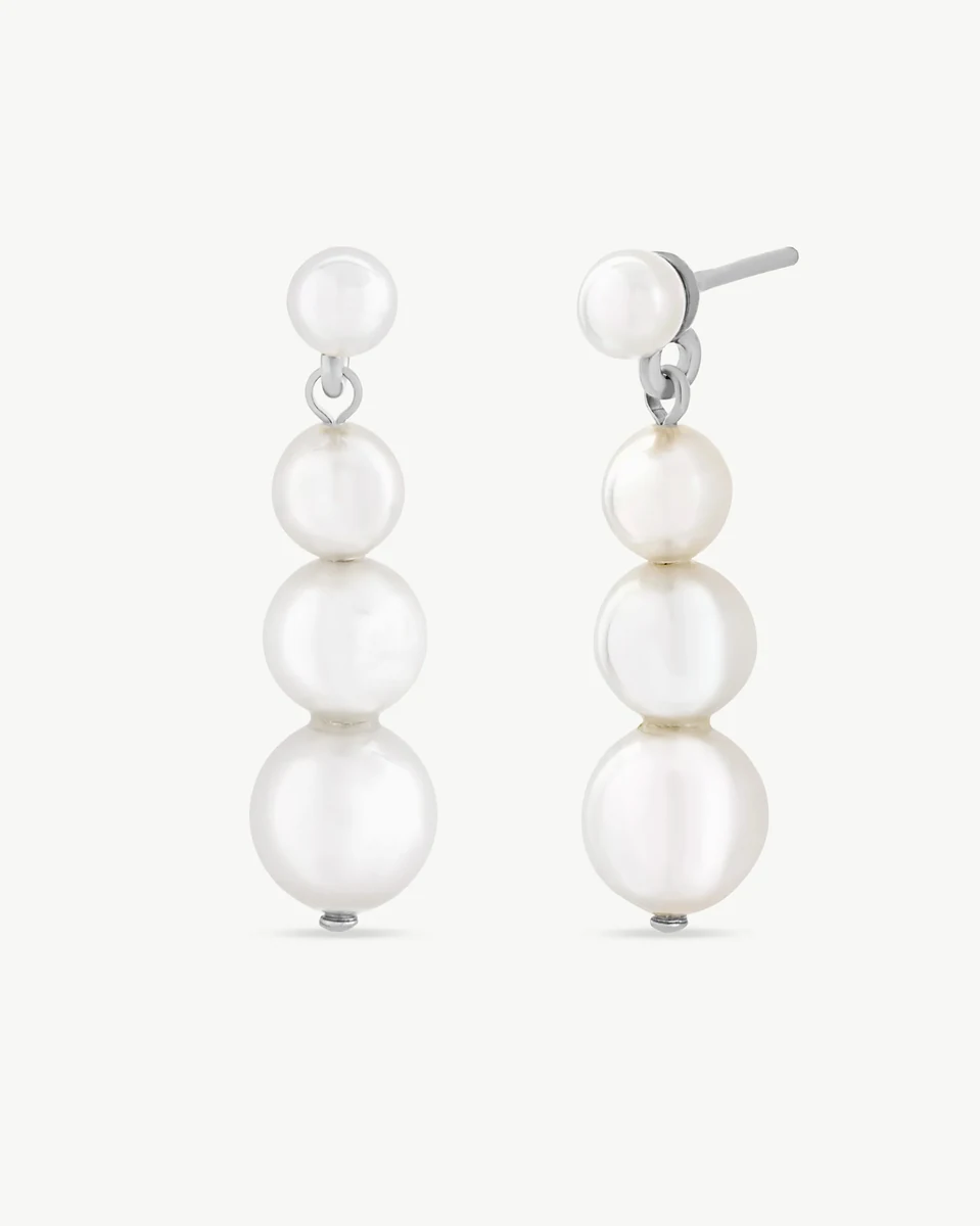 Pareja de pendientes largos con perlas graduadas, vista frontal y lateral sobre fondo blanco.