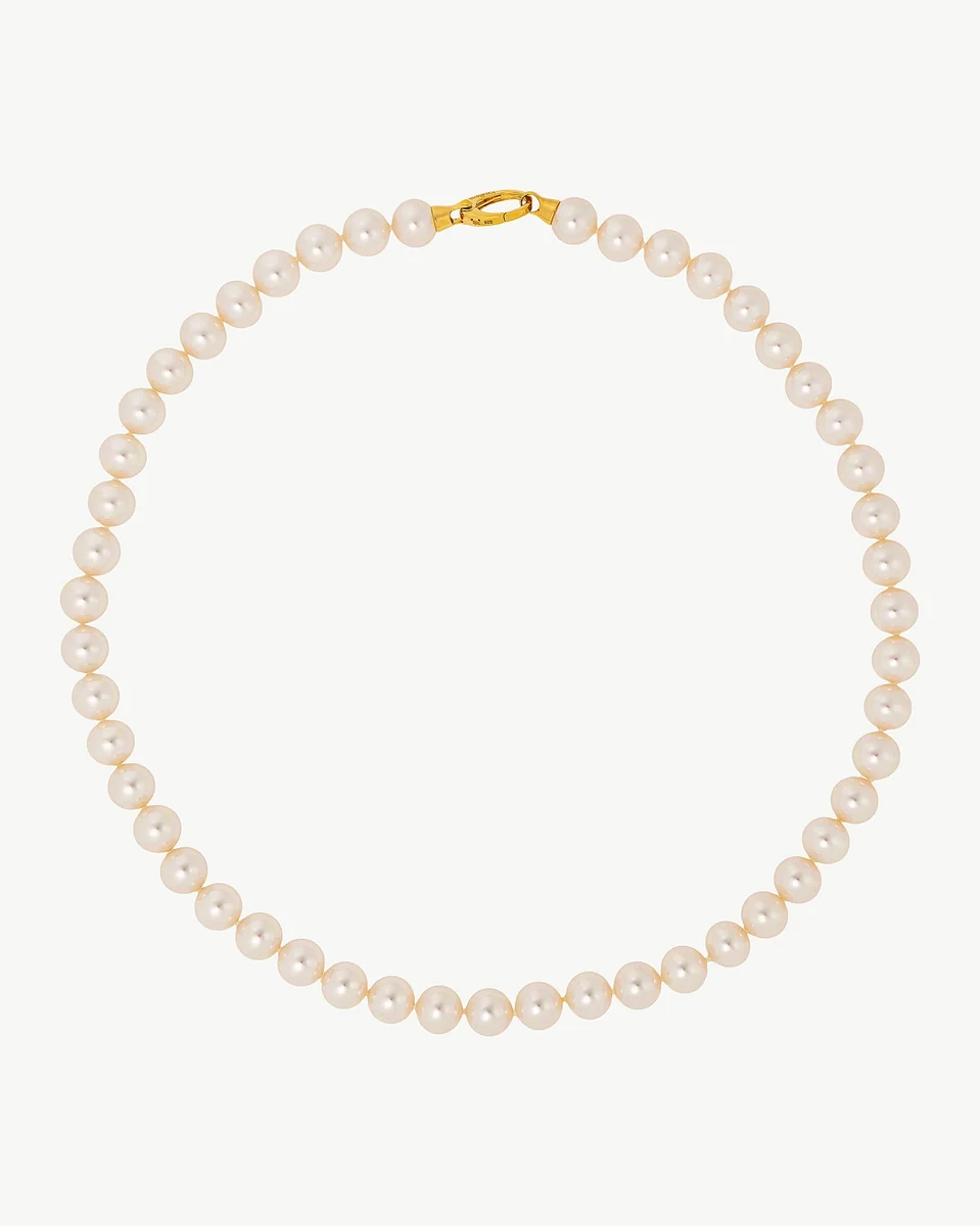 Pearl necklace arranged in a circular shape on a white background, full frontal view.