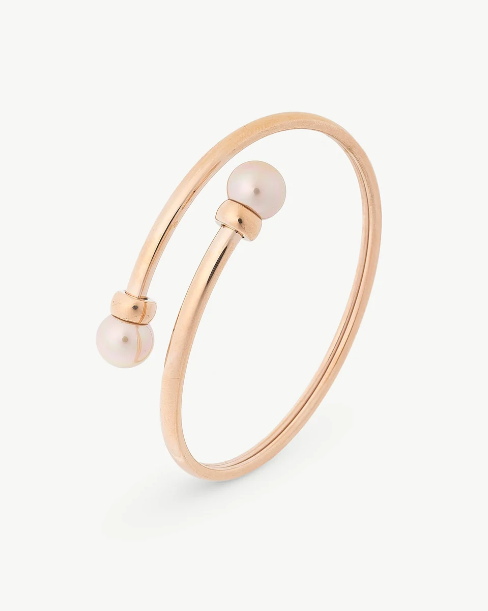 Bracelet jonc en acier rose avec deux perles, vue de profil sur fond blanc.