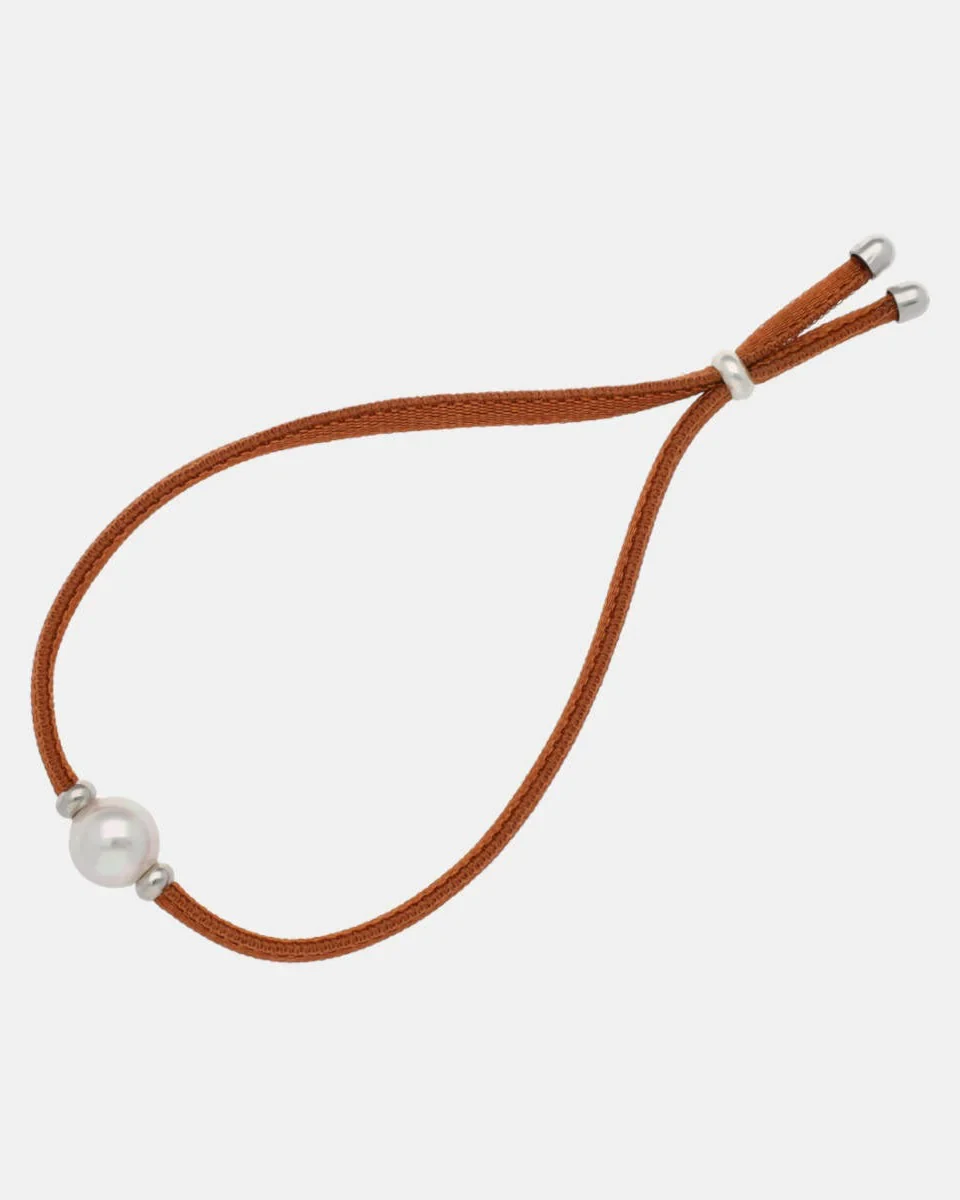 Copper cord bracelet with white pearl, front view on a pure white background.