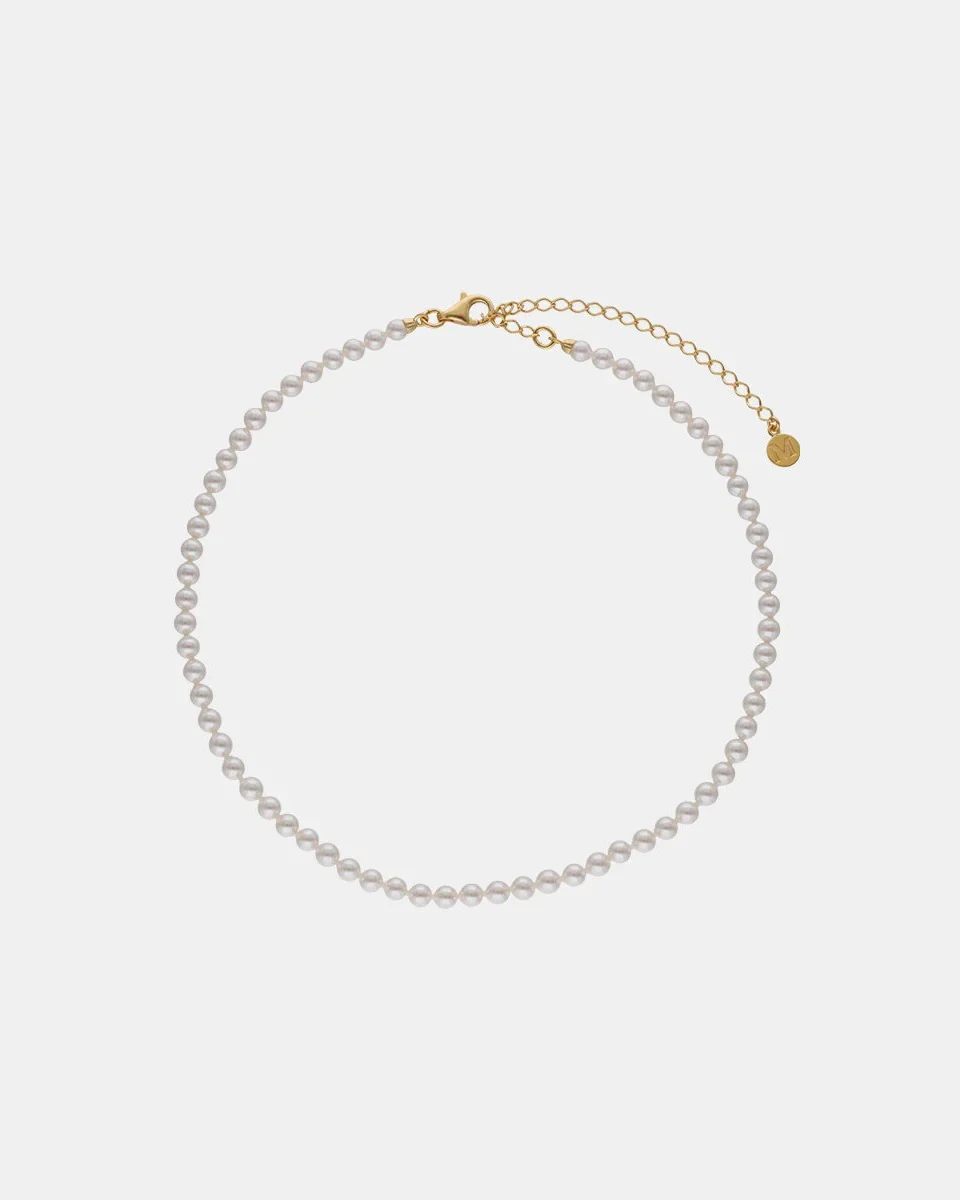 Pearl necklace arranged in a circle on a white background, front view showing clasp and extension chain.