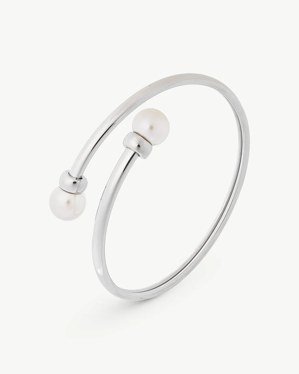 Bracelet jonc en acier avec deux perles blanches, vue de profil sur fond blanc.