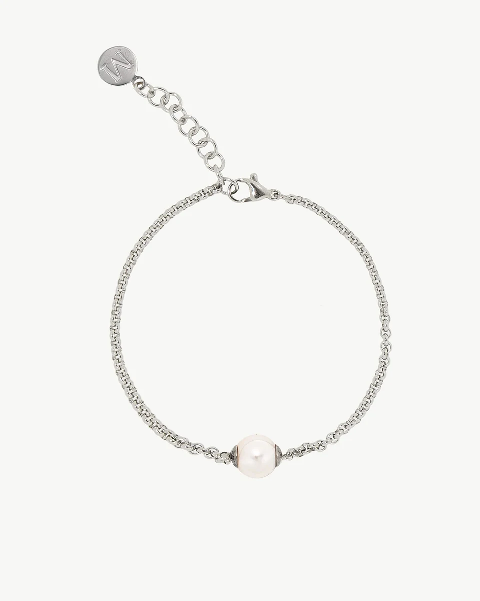 Kettenarmband mit weißer Perle, Frontansicht auf weißem Hintergrund, Detail von Verschluss und Markenanhänger.