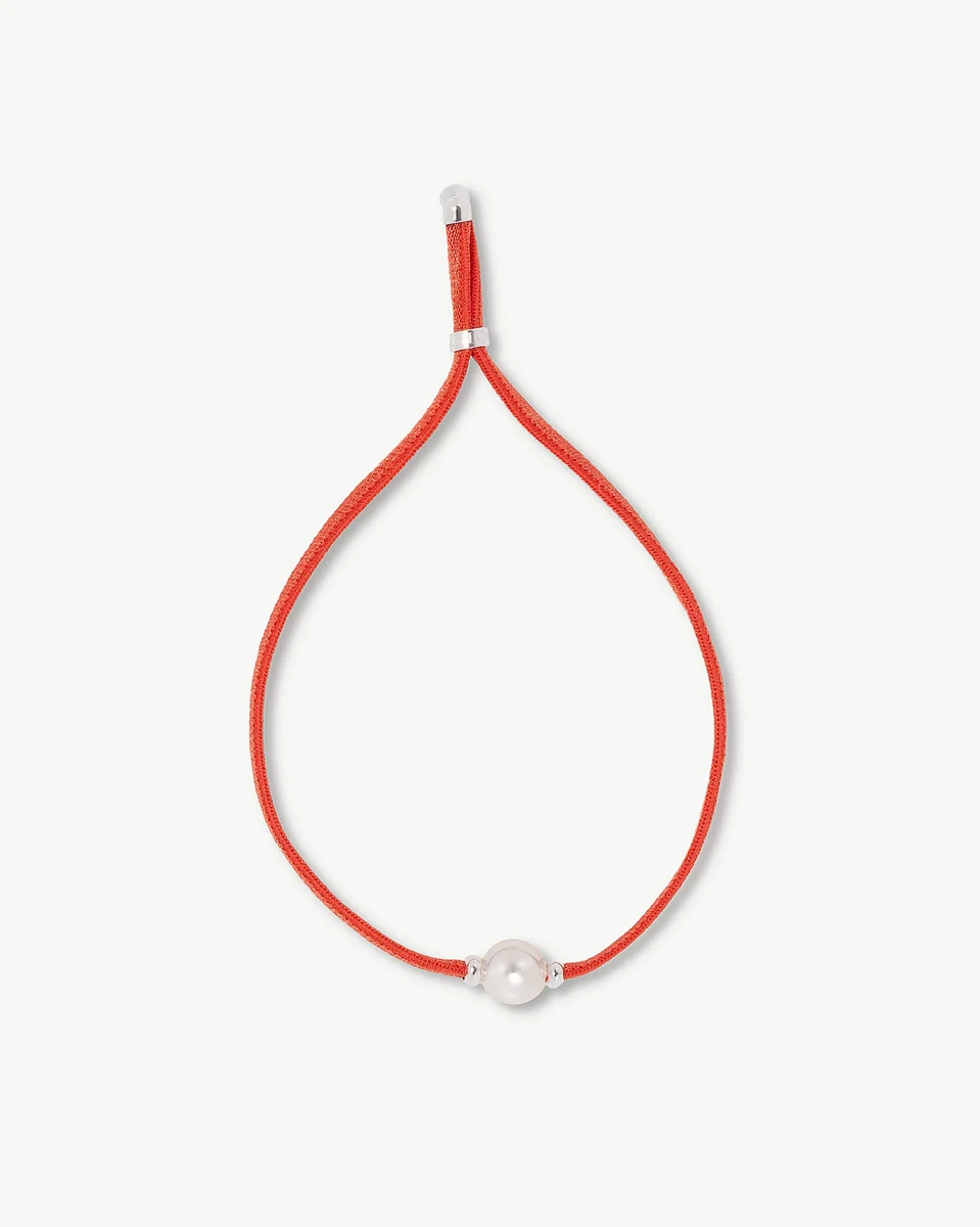 Red bracelet with white pearl in a loop shape, front view on a white background.