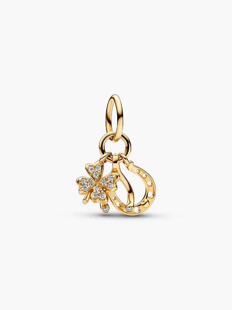 Gold charm pendant shown from a side angle, white background, detail of symbols and cubic zirconia.