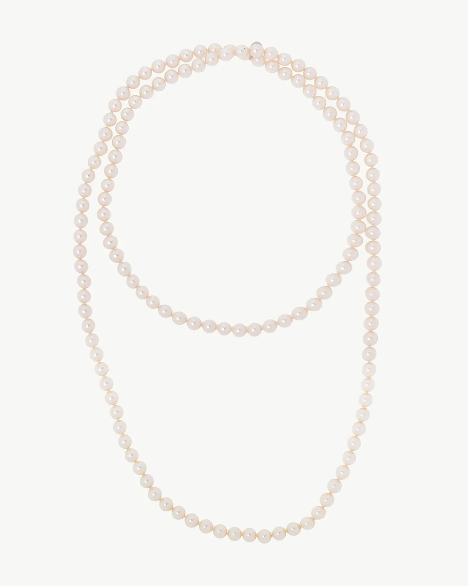 Vista cenital de collar de perlas blancas dispuesto en doble vuelta sobre fondo blanco