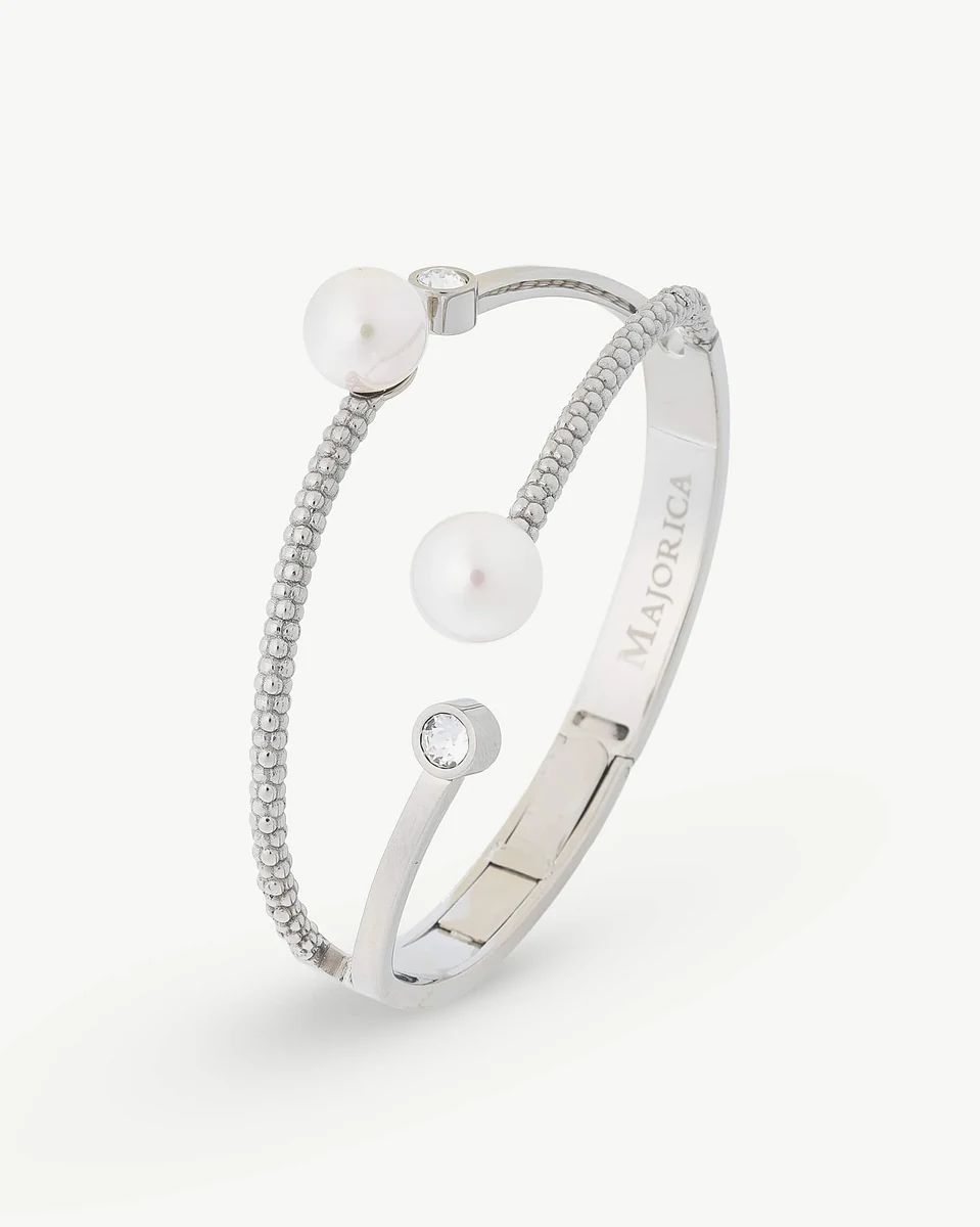 Bracelet jonc en acier avec perles blanches, vue de profil sur fond blanc.