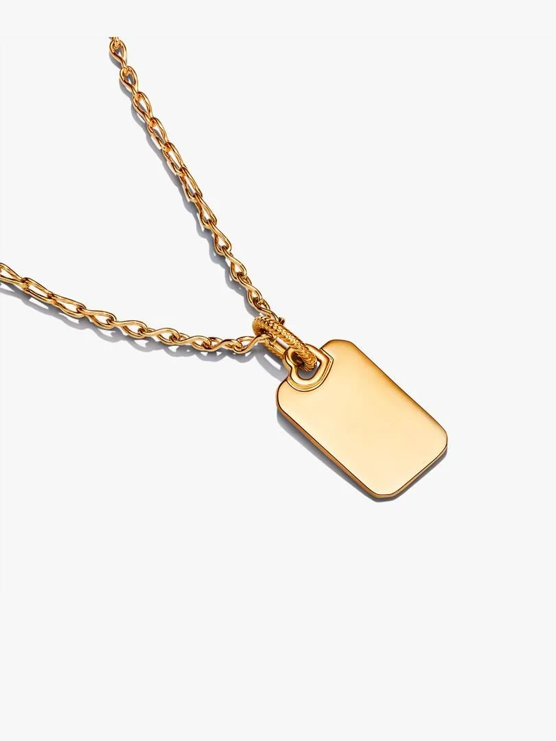 Collar con colgante rectangular dorado sobre fondo blanco, toma en ángulo diagonal.