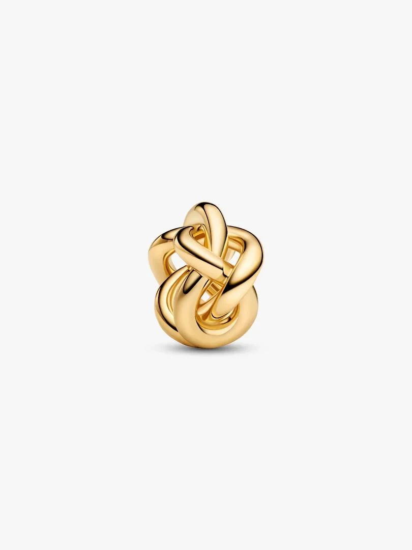 Infinity knot charm in gold tone, front view at a slight high angle on a white background.