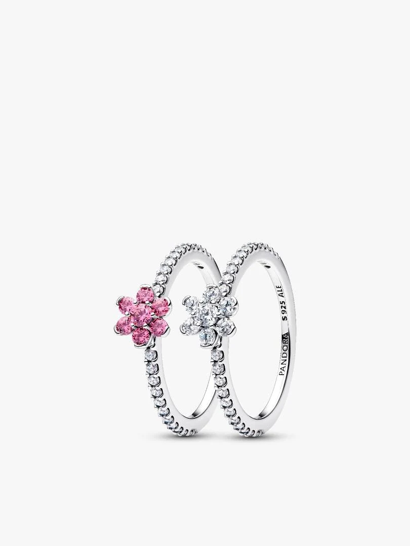 Vooraanzicht van twee verstrengelde ringen met bloemmotieven op een witte achtergrond.