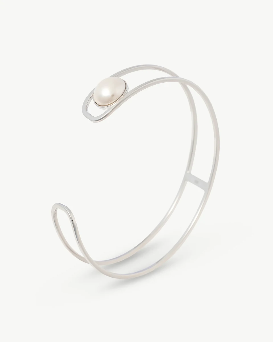 Bracelet en argent avec perle blanche vu de profil sur fond blanc pur.