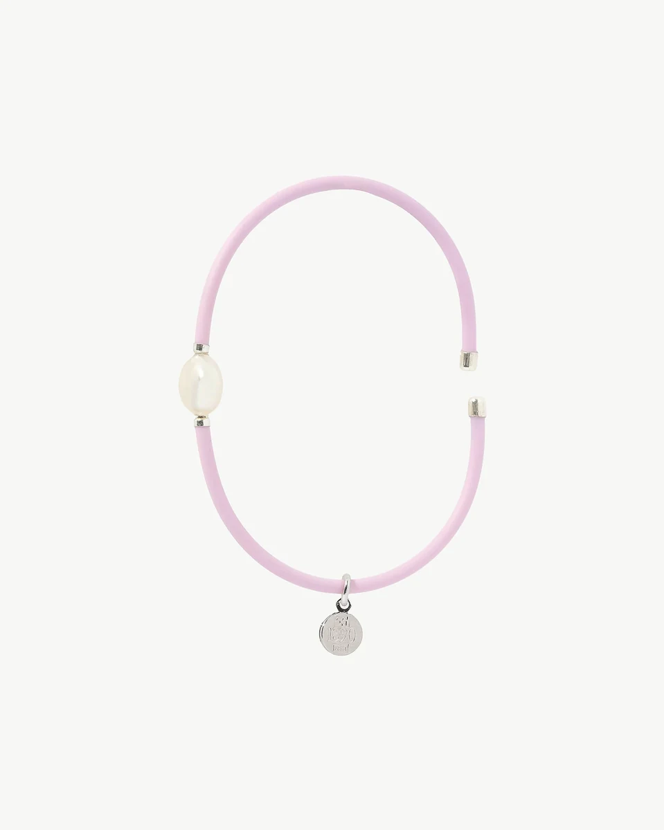 Brazalete rosa con perla blanca visto de frente, toma frontal sobre fondo blanco puro.
