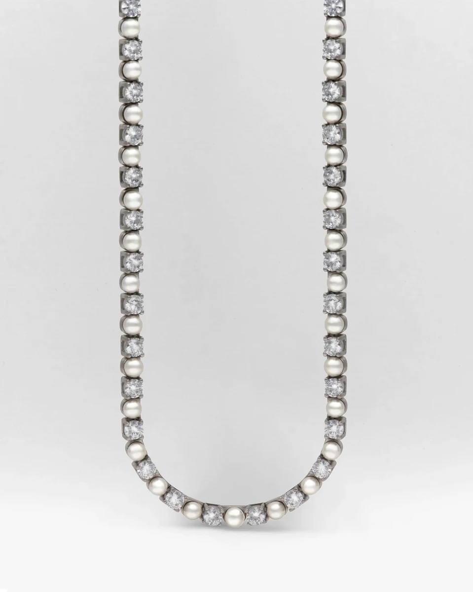 Collier en perles et zircons disposé en forme de U sur fond blanc, vue frontale complète.
