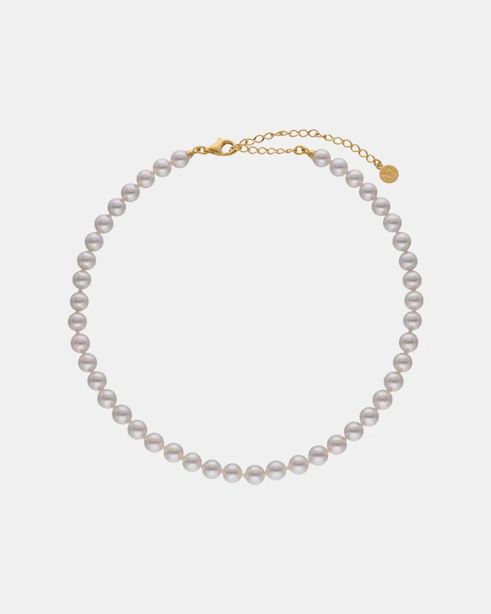 Pearl necklace arranged in a circle on a white background, front view with gold clasp visible.