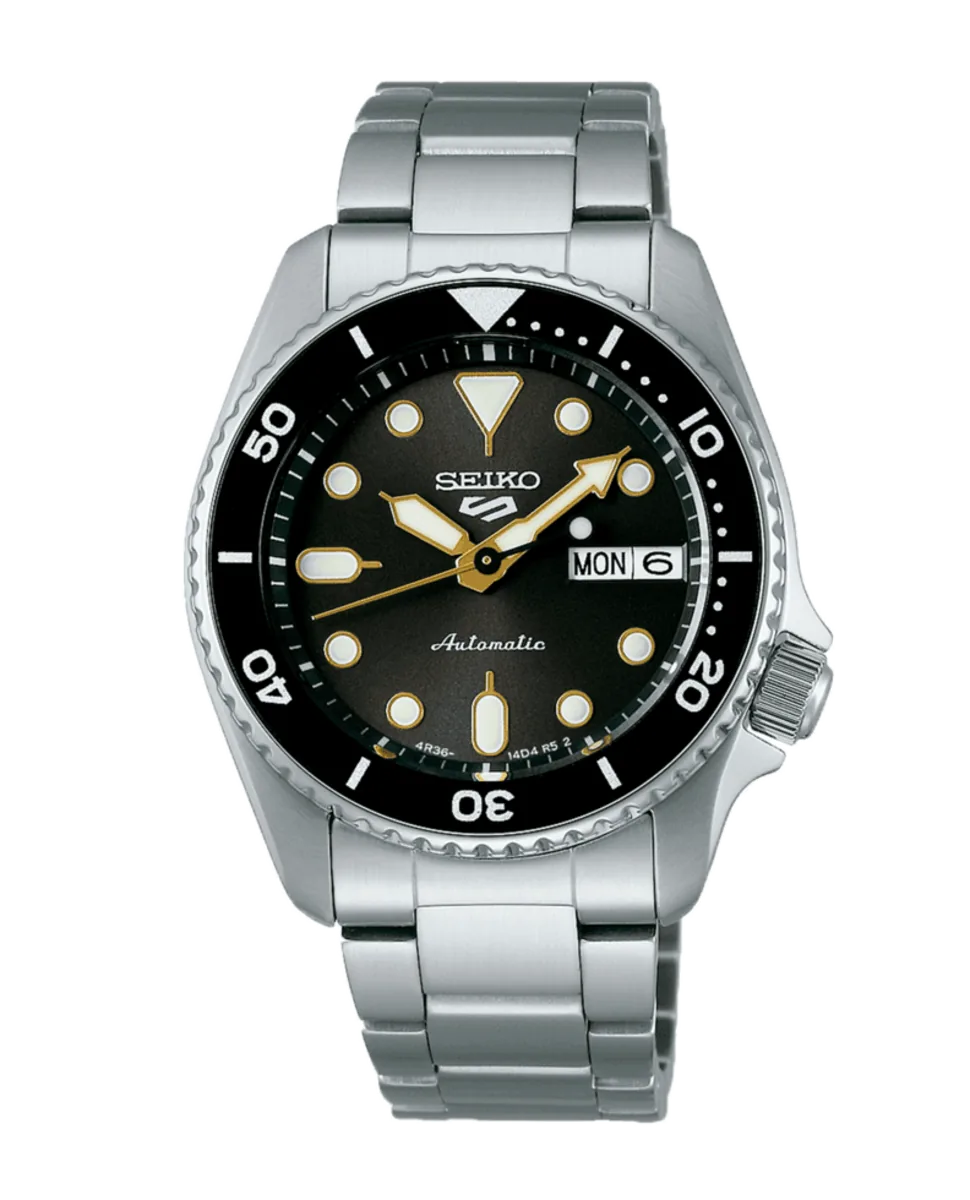 Vista frontal completa del reloj con brazalete de acero, esfera negra y bisel rotatorio sobre fondo blanco.