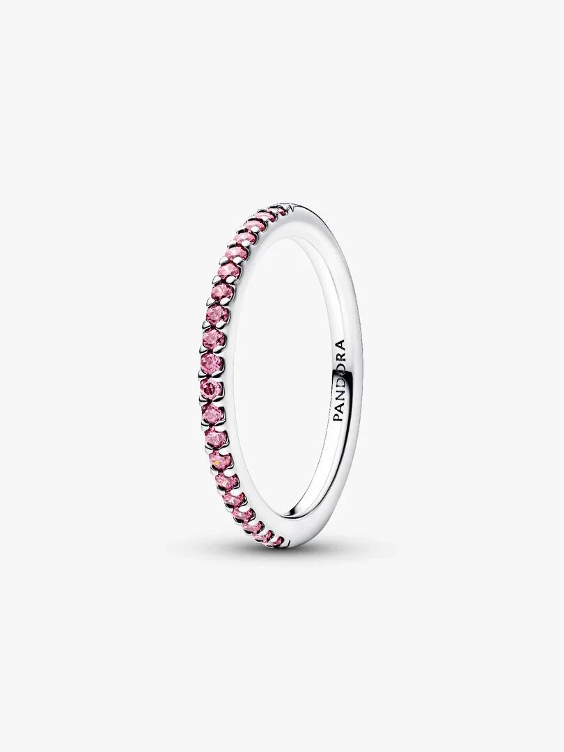 Zijaanzicht van een ring met roze zirkonia's op een neutrale witte achtergrond.