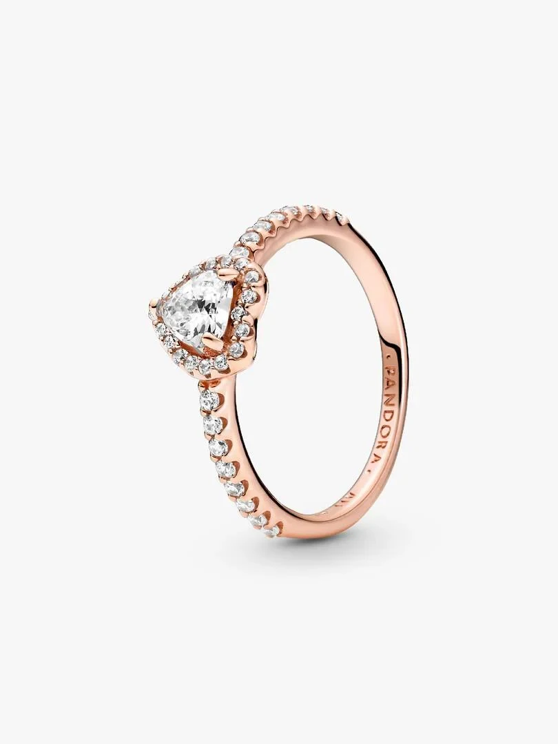 Rose gold ring with heart-shaped center stone, angled side view on a white background.