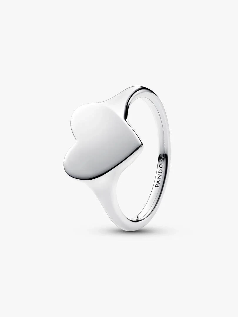 Silver heart ring shown from a side angle, white background, featuring the brand engraving.
